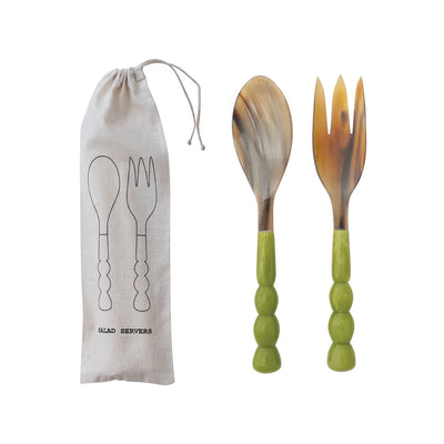 Set of salad servers with green handles and a carrying bag on a white background