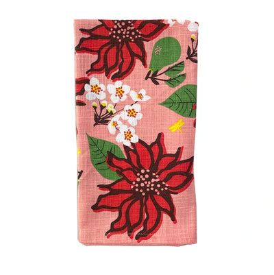 Square cloth napkin with a pink background and a poinsettia and floral print folded in quarters.