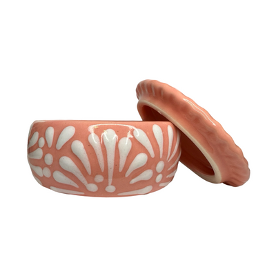 Ceramic container with white floral patterns on a peach-colored background