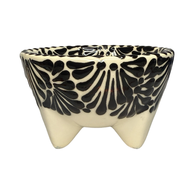 Handcrafted ceramic molcajete-style bowl with a black floral design on a cream background and three short legs.
