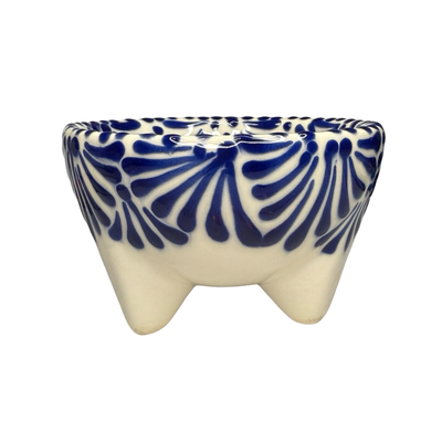Handcrafted ceramic molcajete-style bowl with a blue floral design on a cream background and three short legs.