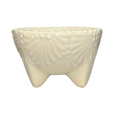Handcrafted ceramic molcajete-style bowl with a white floral design on a cream background and three short legs.
