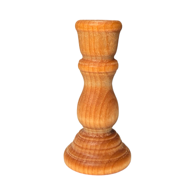 Small wooden candle holder with a smooth natural finish and rounded base, designed for taper candles.