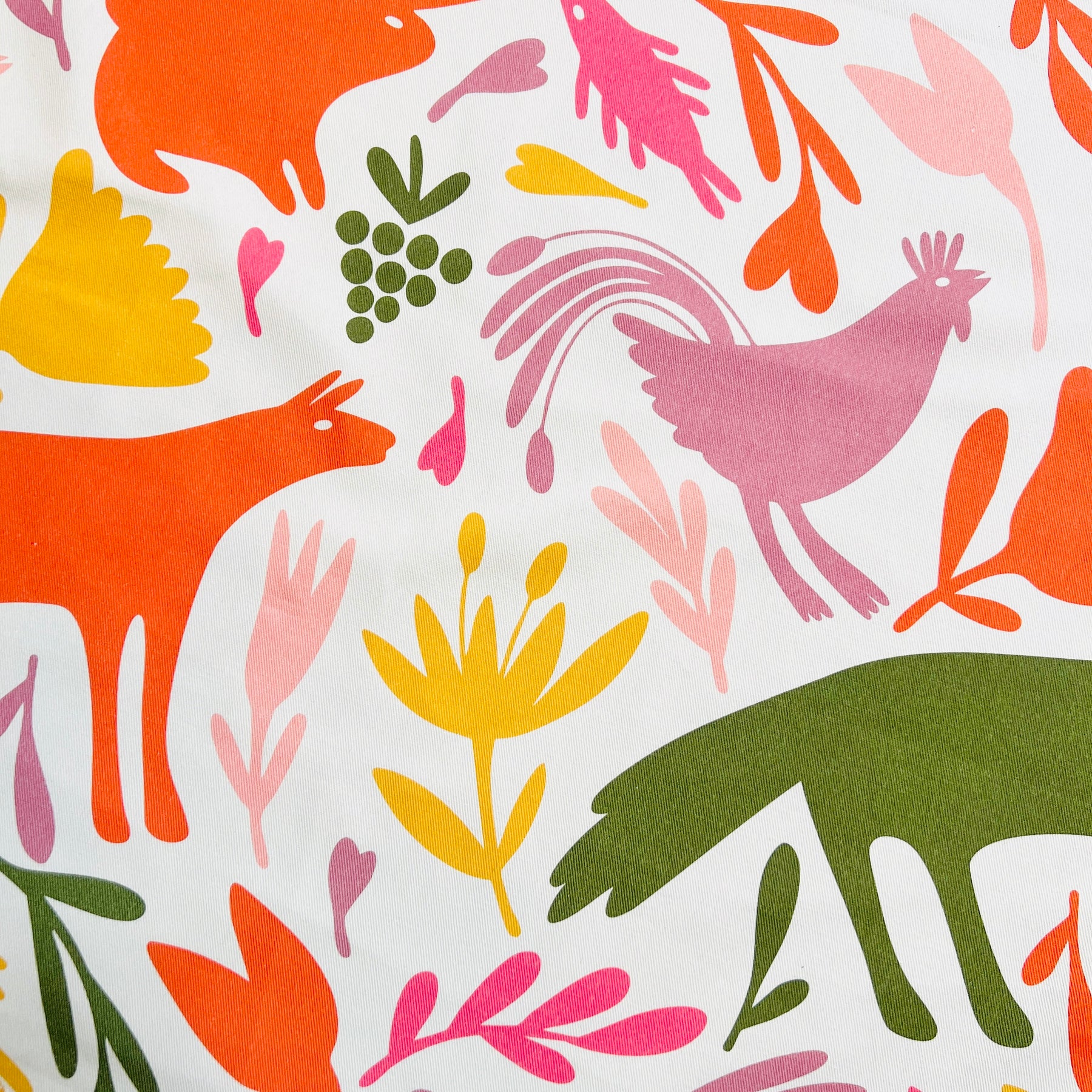 Close up of orange, pink, light pink, sage green and yellow otomi designed apron