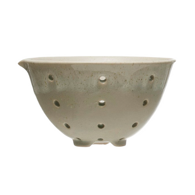 Beige stoneware berry bowls with drainage holes and a smooth glazed finish.
