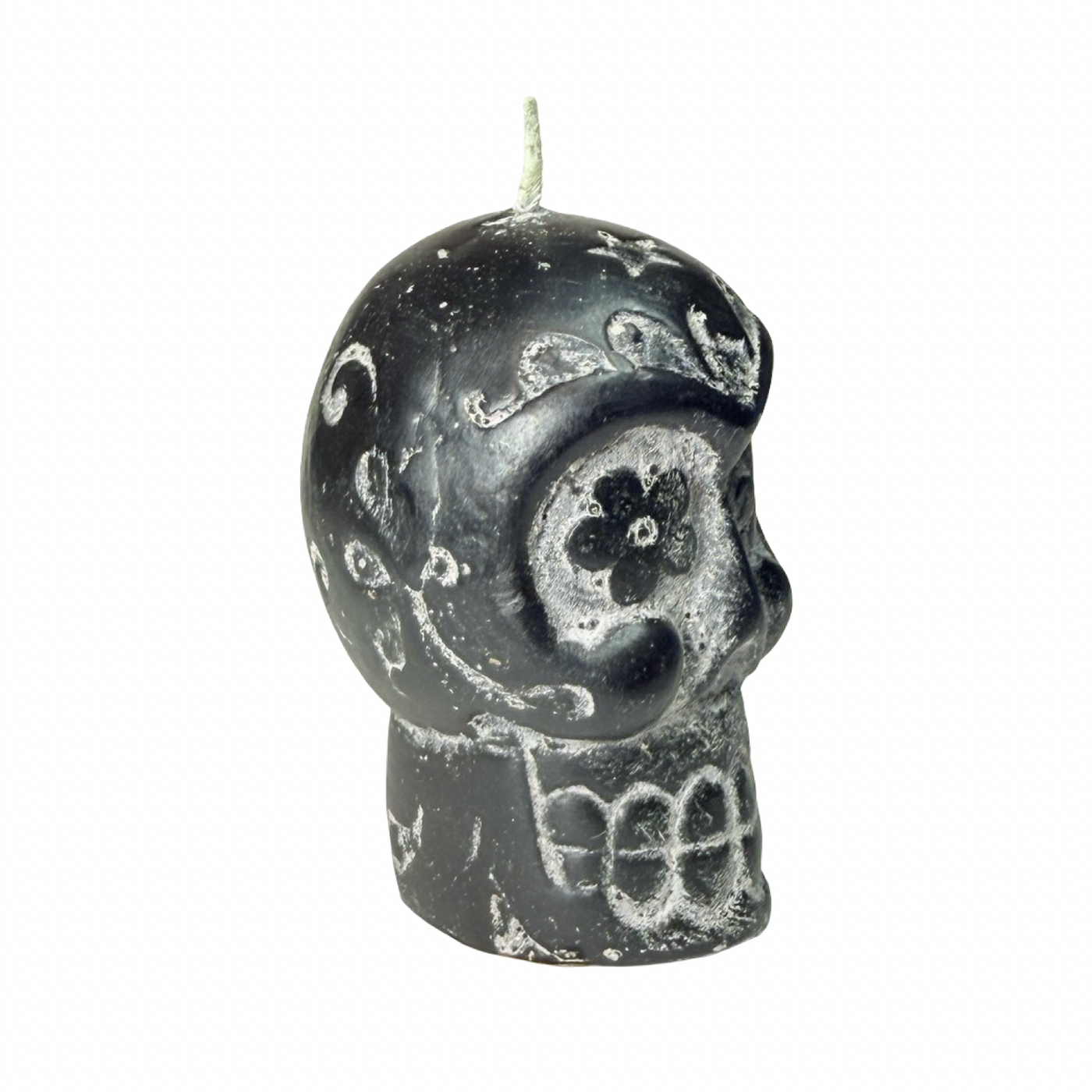 Side view of black skull-shaped candle with decorative patterns 