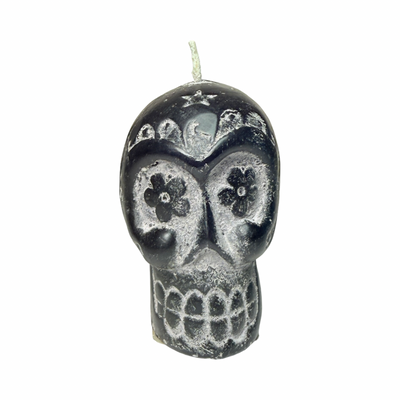 Black skull-shaped candle with decorative elements 