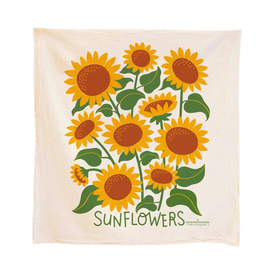Cotton tea towel with a colorful sunflower design, showing large yellow blooms with green leaves on a cream background.