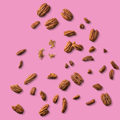 Pecans scattered on a pink background