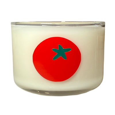 Candle with a red tomato design on a white background