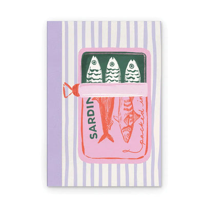 Notebook with a sardine tin illustration on the cover in pink, green, and coral tones, set against a striped background.