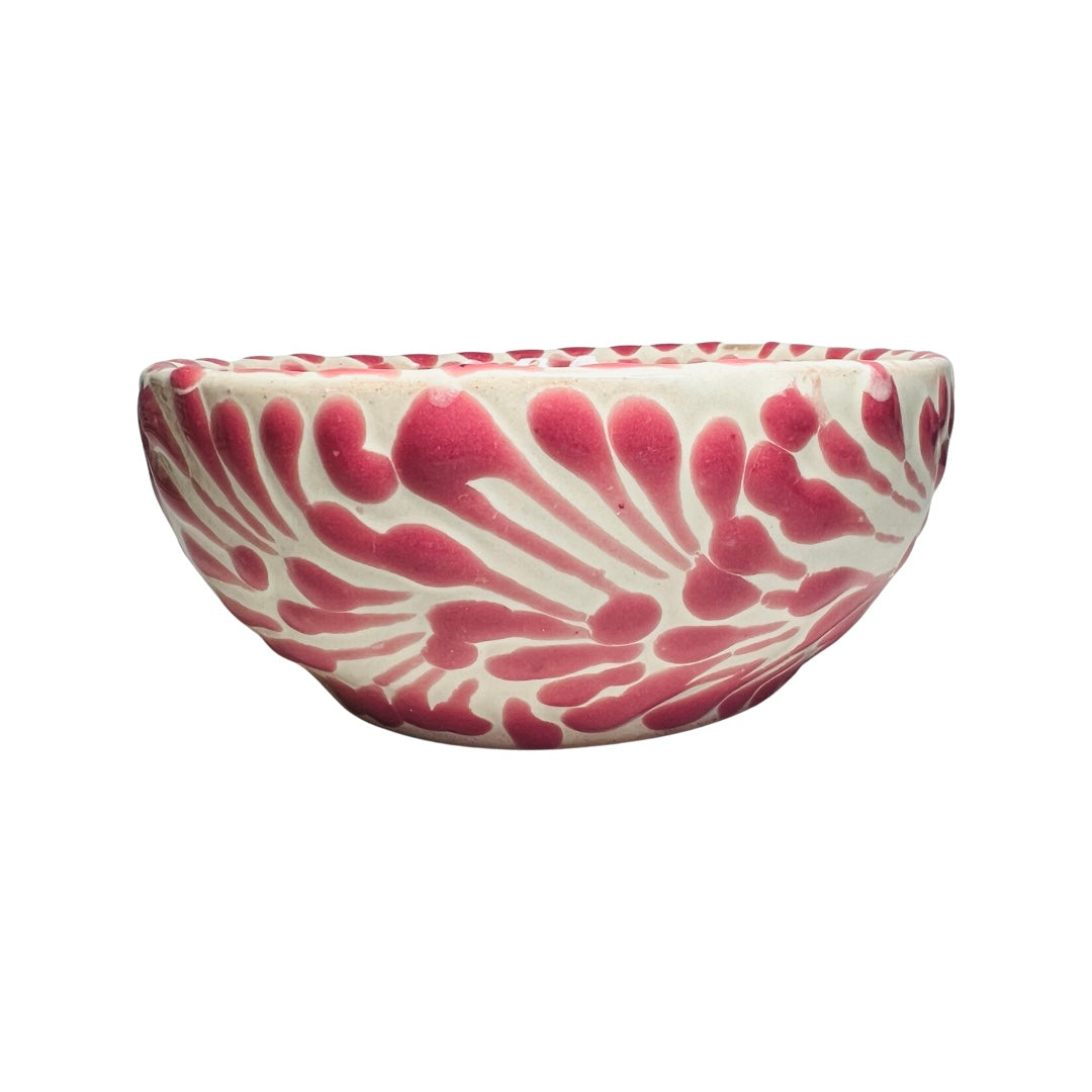 Side view of a ceramic bowl with a white and pink Puebla design