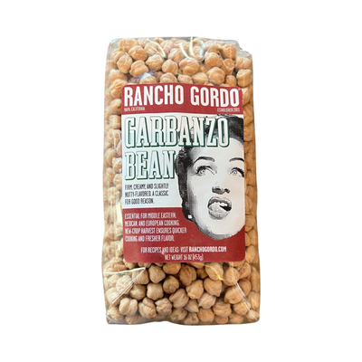 16 oz clear bag of garbanzo beans with a white and maroon branded label featuring an image of a woman licking her lips.