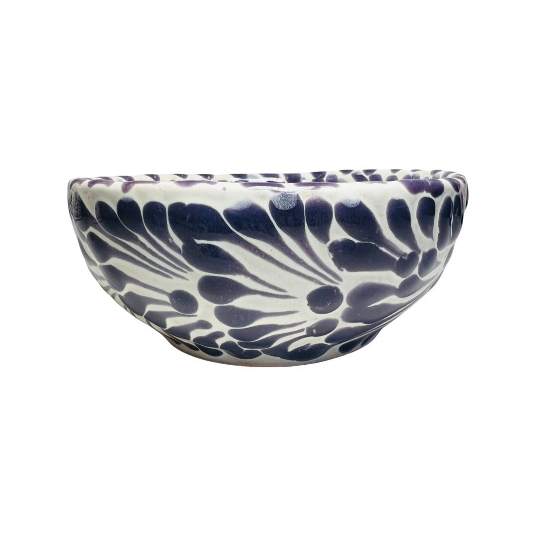 Side view of a ceramic bowl with a white and purple Puebla design