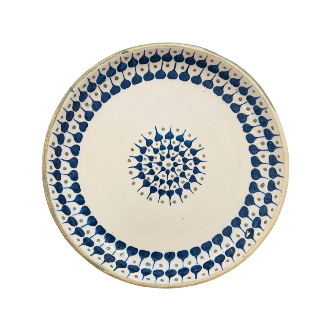 Cream ceramic dinner plate with a blue and brown design