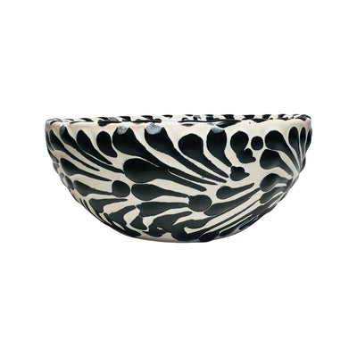 SIde view of a ceramic bowl with a white and black Puebla design