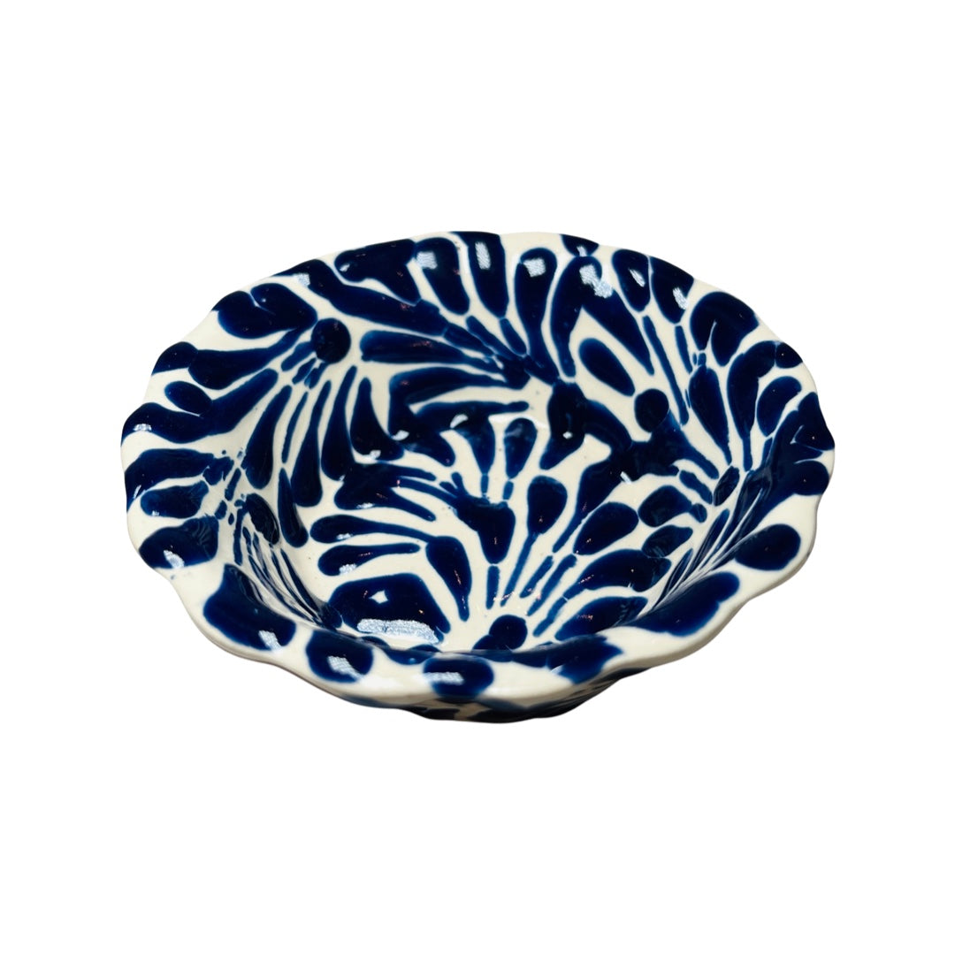 top view of a blue and white Puebla design ceramic bowl with a scalloped edge