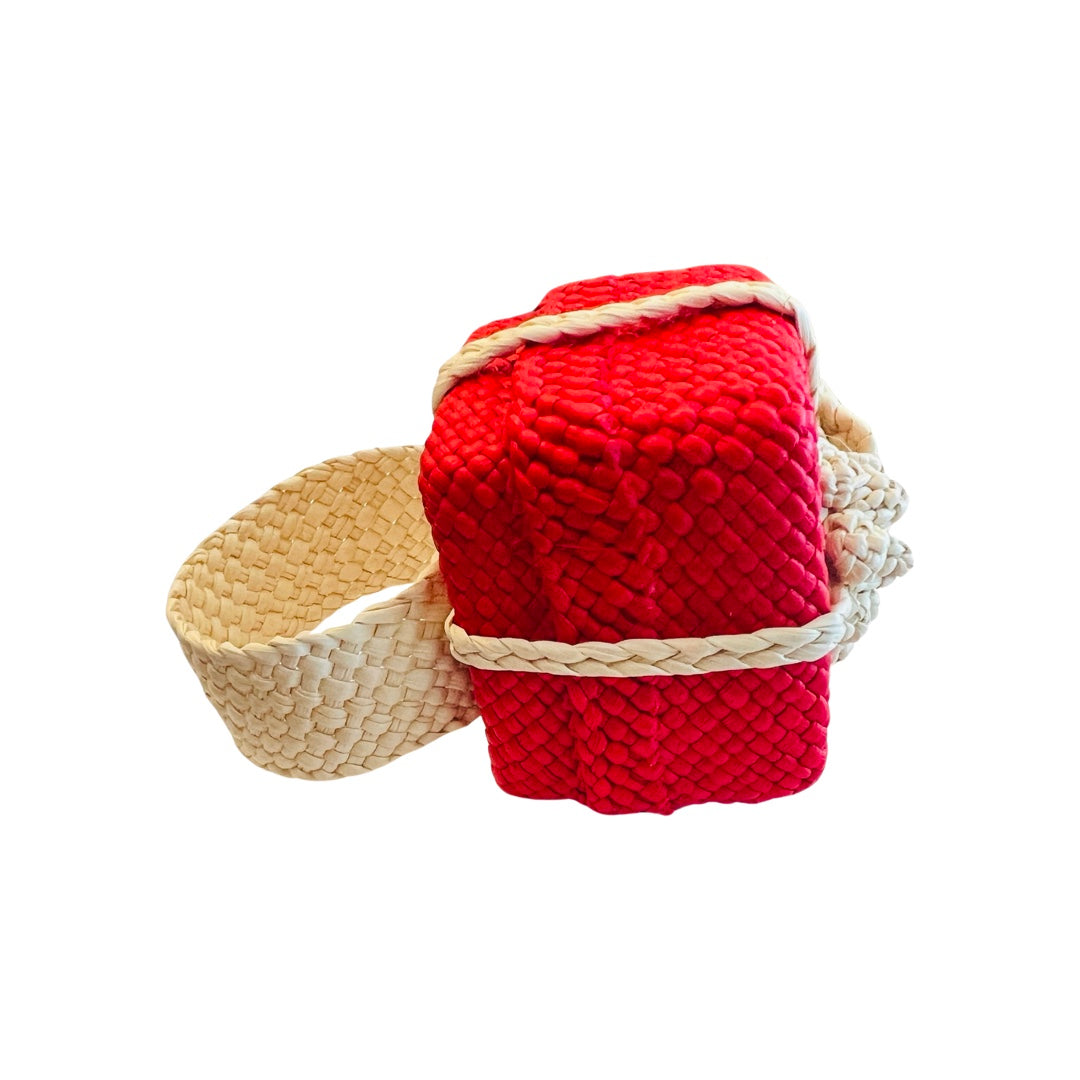 side view of A woven napkin ring designed as a festive Christmas gift, featuring a red box with a braided natural fiber bow, perfect for adding a holiday touch to your table decor.