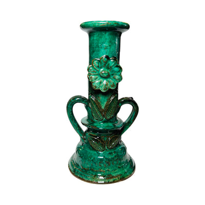 Green candlestick holder featurig two handles and a flower on the center.