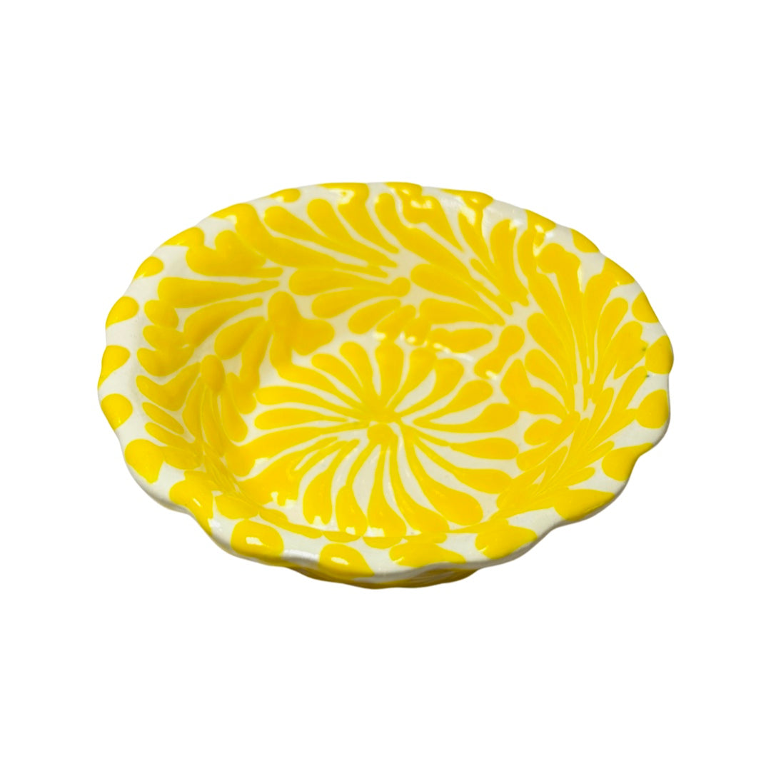 top view of a yellow and white Puebla design ceramic bowl with a scalloped edge