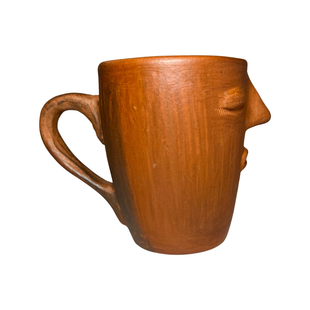 side view photo of clay mug with handsculpted face design