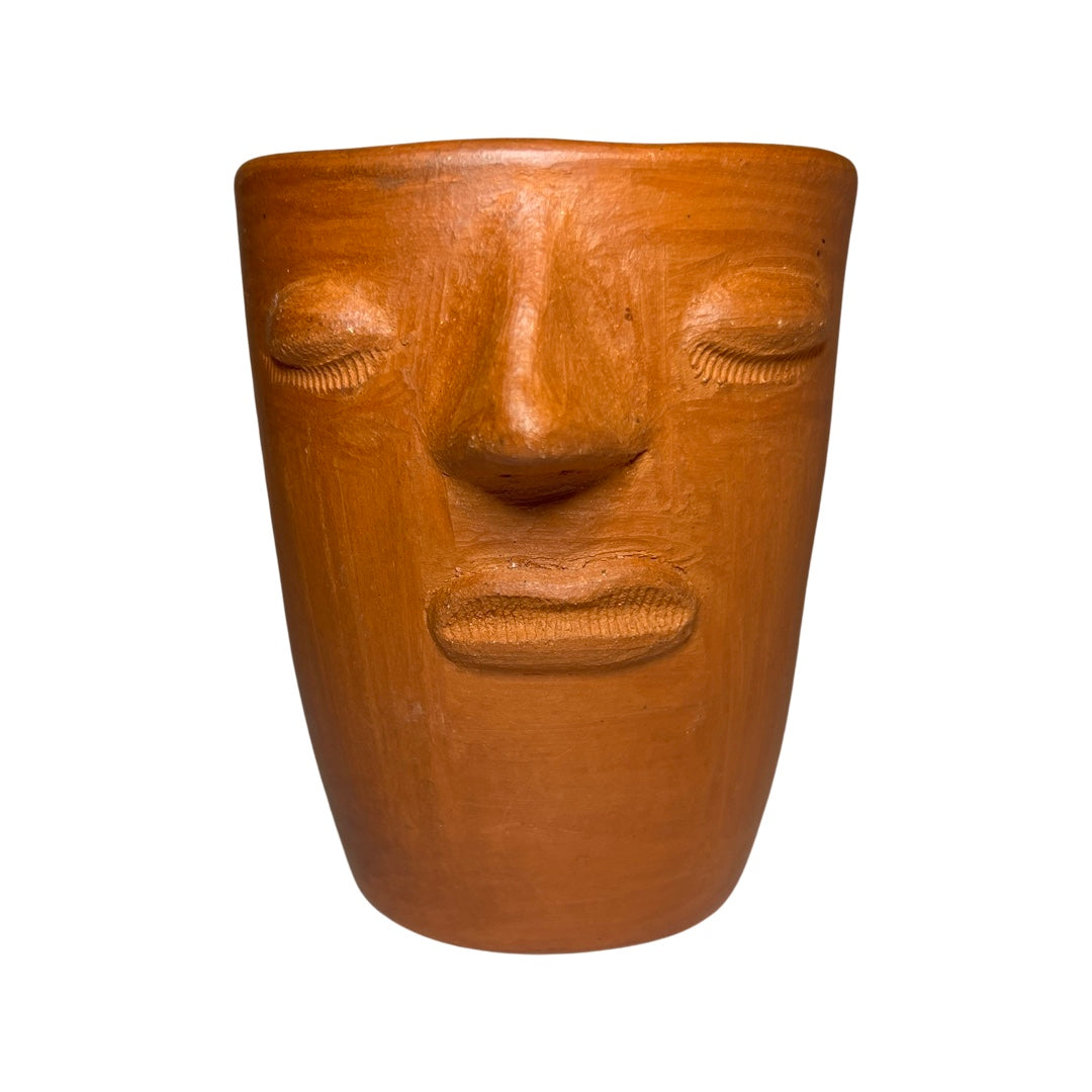 front view photo of clay mug with handsculpted face design
