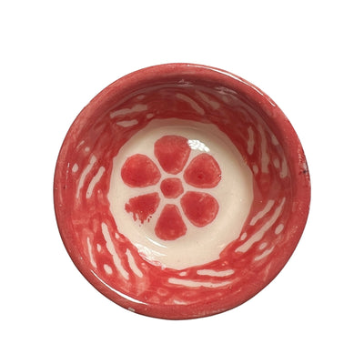 red ceramic bowl with a flower design