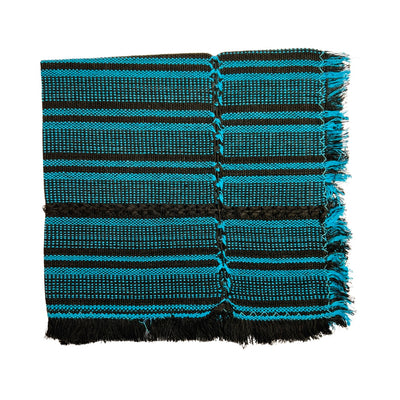 black and turquoise striped handwoven napkin folded in quarters