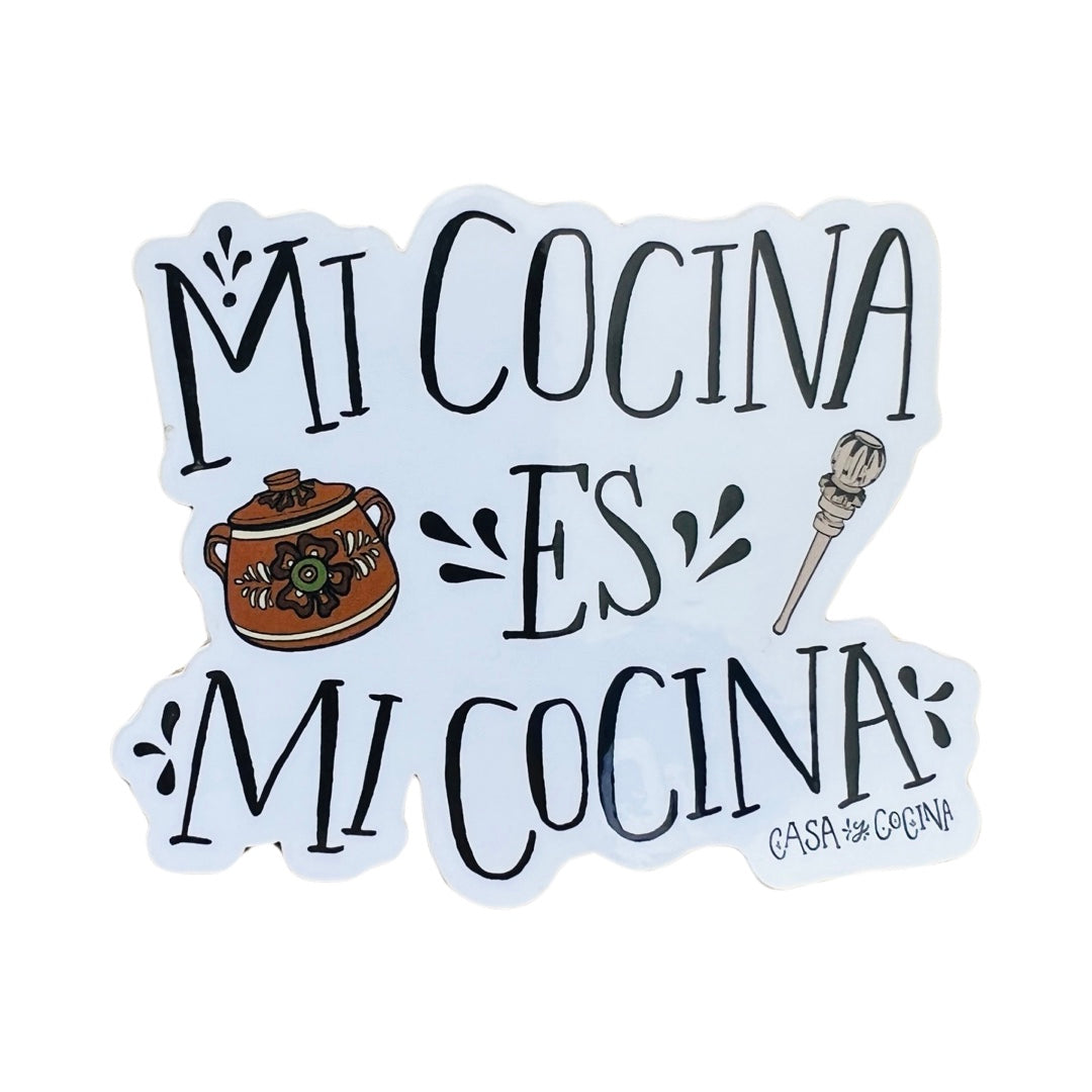 white sticker with the phrase Mi Cocina es Mi Cocina in black lettering and features an image of a Mexican Clay pot and molinillo.