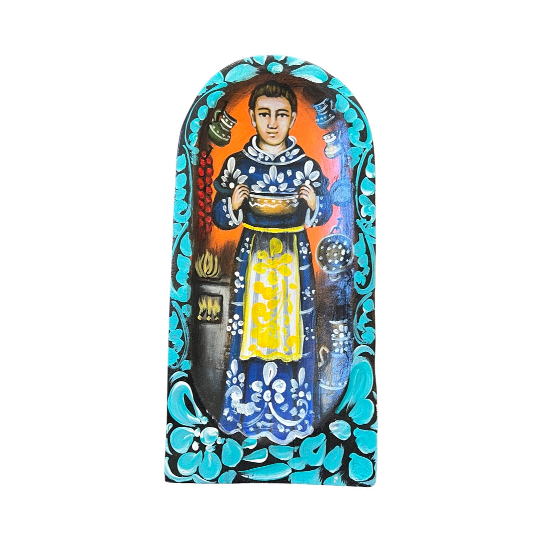 San Pascual retablo featuring an image of San Pascual holding a pitcher in a kitchen with the image bordered with multi-colored flowers and filagree