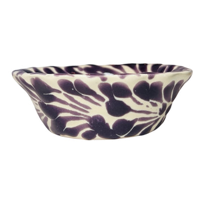 side view of a purple and white Puebla design ceramic bowl with a scalloped edge
