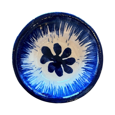 top view of a royal blue ceramic mini bowl featuring a flower design in the center.