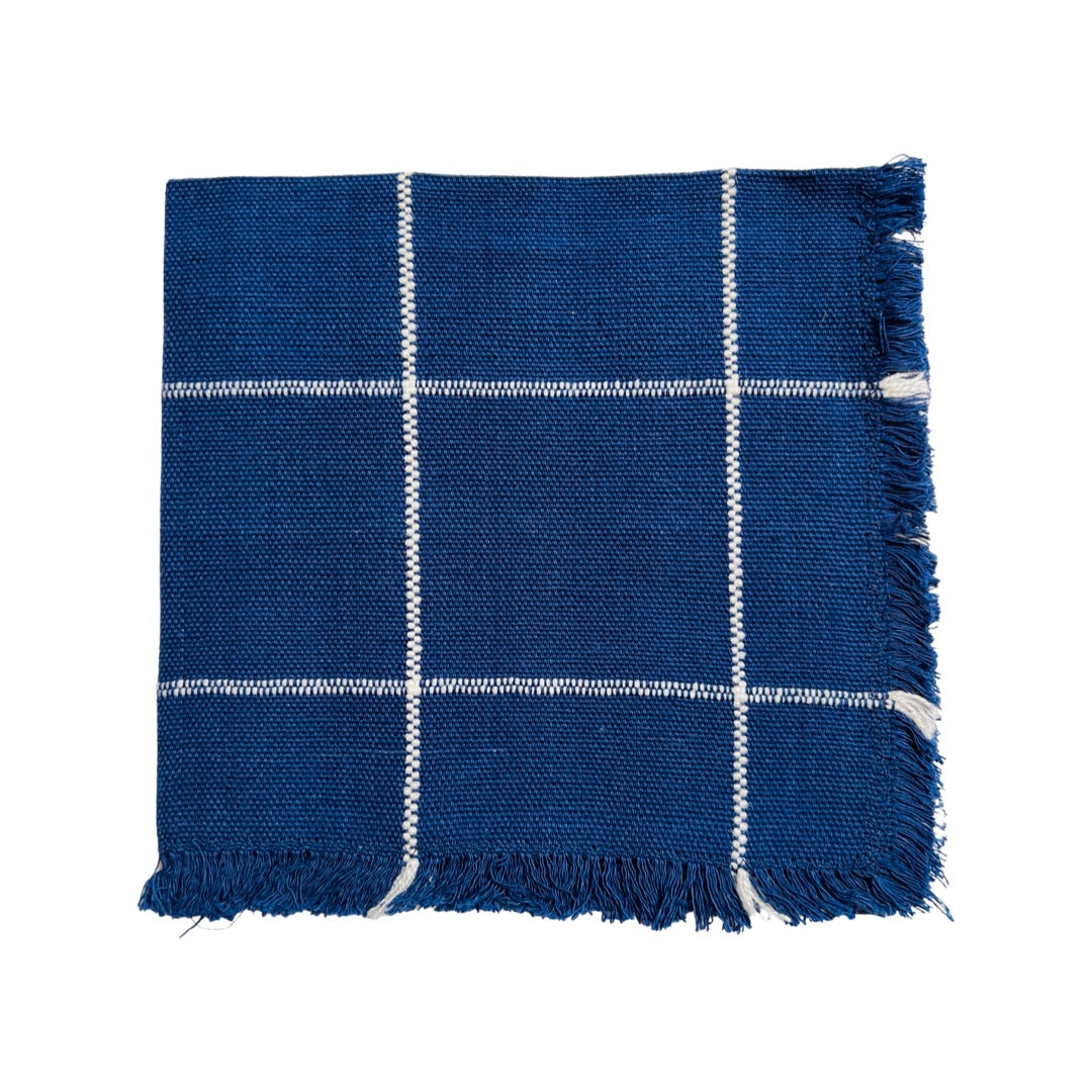 Navy blue and white plaid napkin folded in quarters.