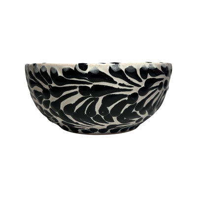 Side view of a ceramic bowl with a white and black Puebla design