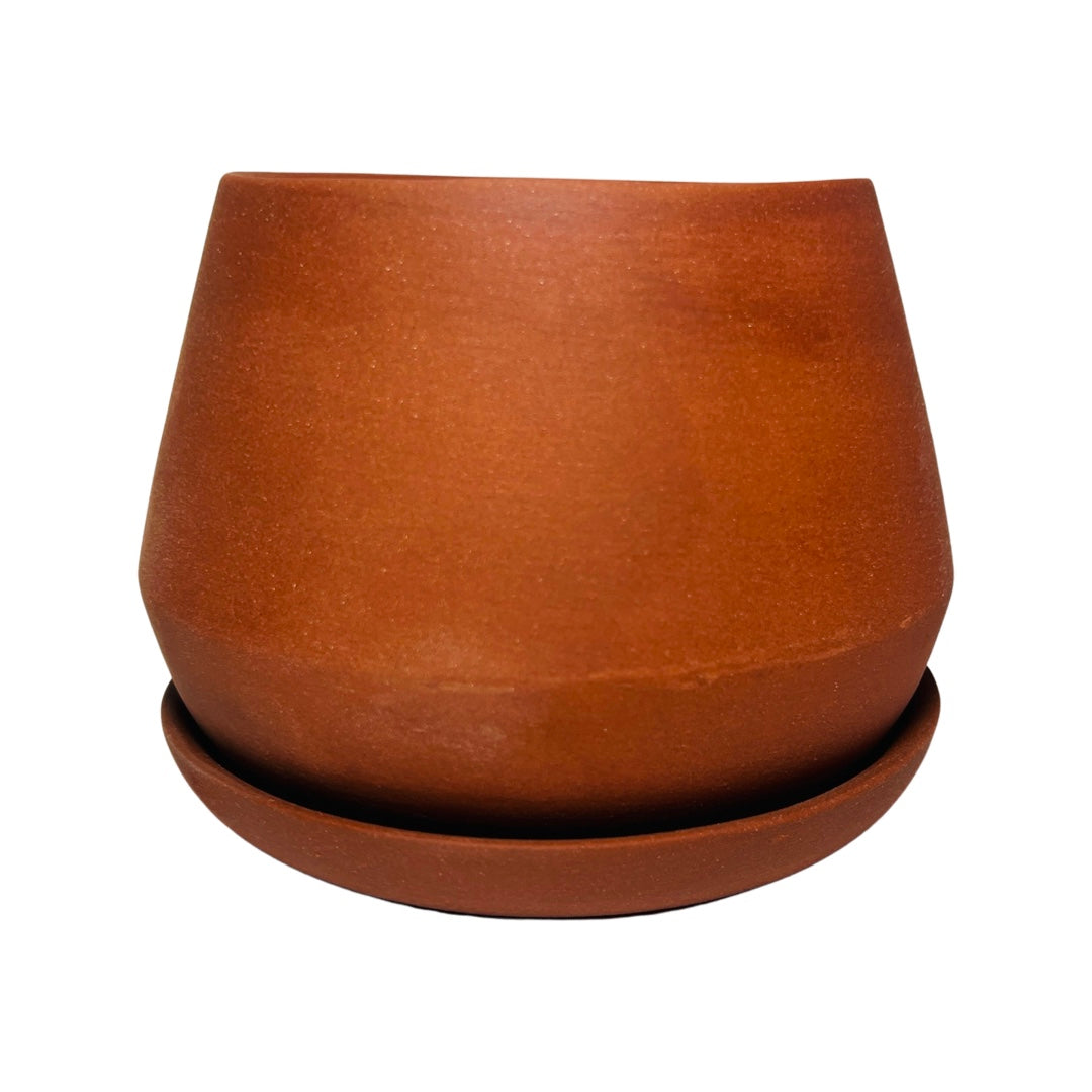 sienna colored ceramic planter that is rounded on the bottom with a wide belly that tapers inward at an angle.
