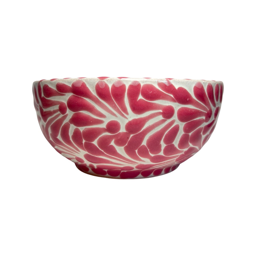 Side view of a ceramic bowl with a white and pink Puebla design