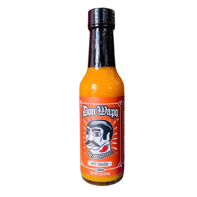 Front view of a glass bottle containing 5 oz of hot sauce. The label is an orange-red and features a graphic of a man with slicked back black hair, giant black eyebrows, a black mustache, and a red chili pepper tattoo on his neck. 