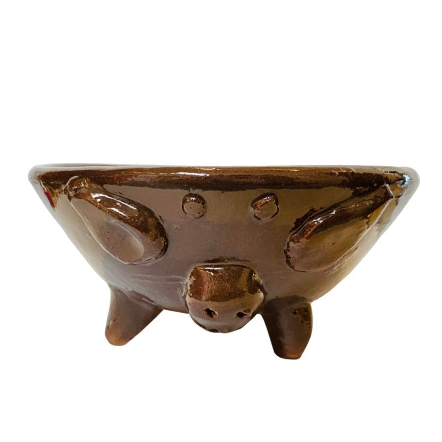 front view of gloss glazed handsculpted bowl with pig facial features and legs