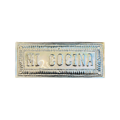 Hammered aluminum sign with 'Mi Cocina' written on it, intended for hanging as kitchen decor.