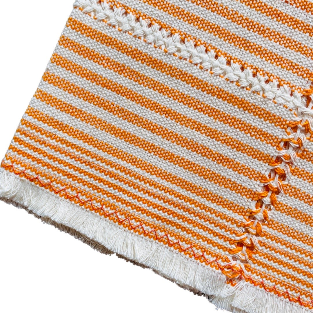 quarter folded tan napkin with orange stripes