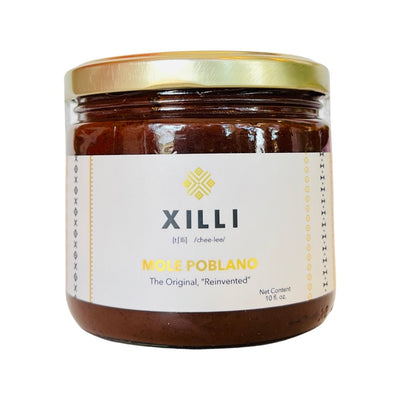 Front view of Mole Poblano in clear glass branded jar with gold colored lid