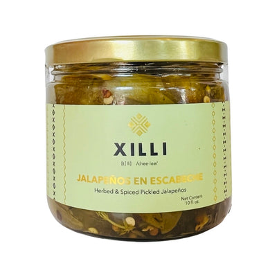 Front view of Jalapeños en Escabeche in clear branded jar with gold lid