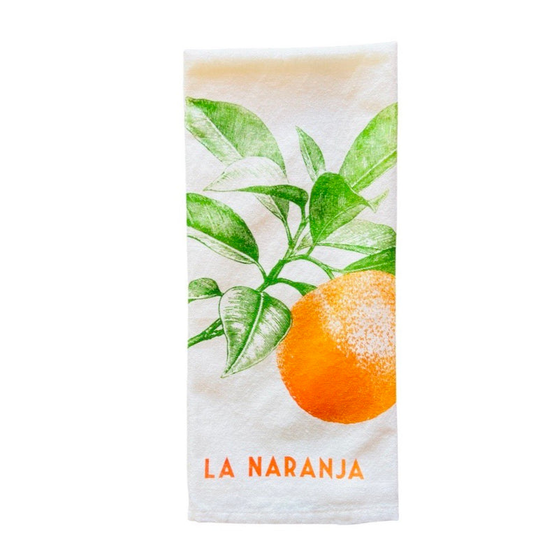folded off white tea towel with printed graphic of orange and orange tree branch, also reads "La Naranja" meaning the orange