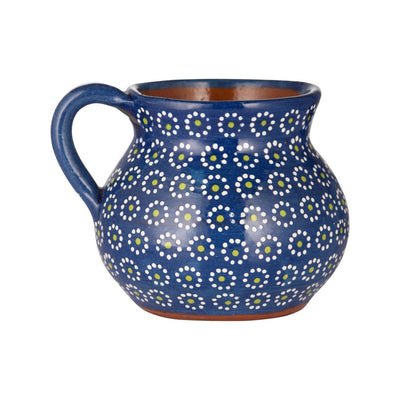 side angle of dark blue colored mug with painted dots resembling the shape of a flower