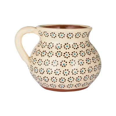 side angle of cream colored mug with painted dots resembling the shape of a flower