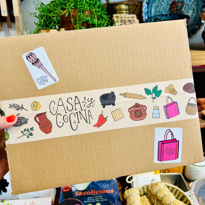 Cardboard box taped with Casa y Cocina branded tape and stickers.