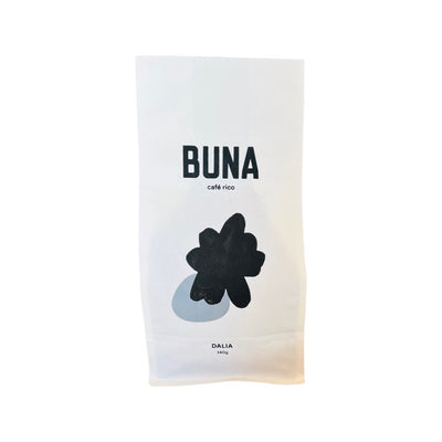A single white 340 gram bag of Buna Coffee that features abstract art of a black splatterover a gray spot on the center of the bag.