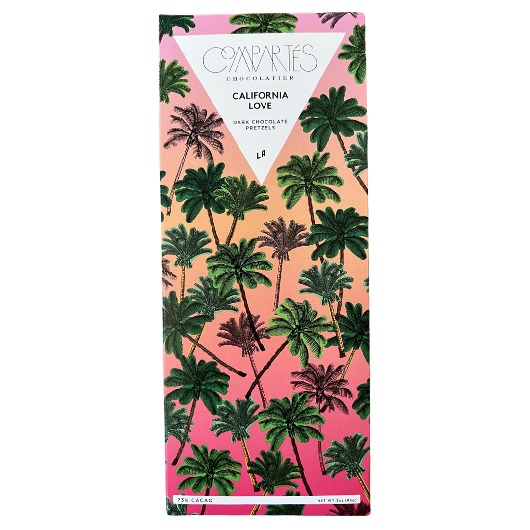 A single chocolate bar of dark chocolate pretzels. Label features a pattern of palm trees with a pink and orange ombre background and a white upside triangle at the top.