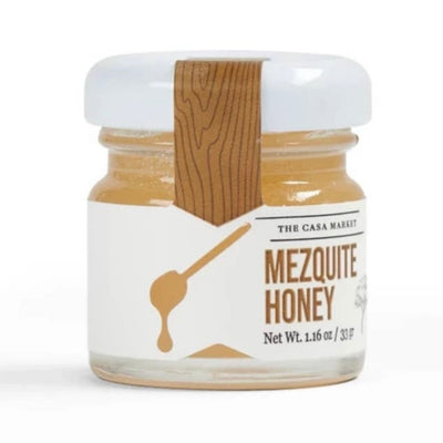 Mini Mezquite Honey in an 1.16 ounce jar with a white branded label that features a honey dipper.