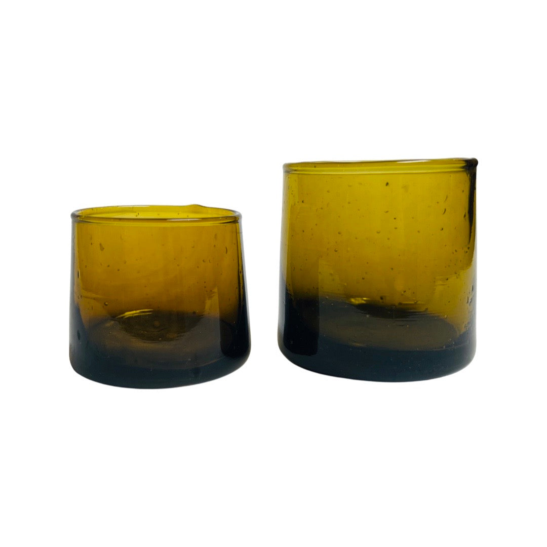 2 translucent amber colored drinking glasses in varying heights